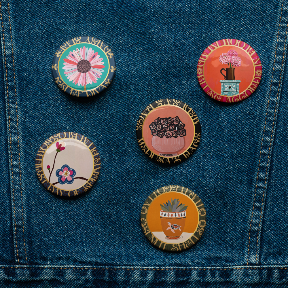 Set of colorful pins on a denim jacket-Five-piece floral medallion art pin set including daisy hydrangea plum blossom rose bouquet and potted succulent pinback buttons by Szeto on a white background